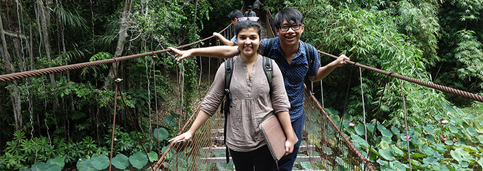 Two students crossing a rope bridge