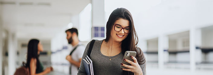 Image of female student smiling and looking at her phone