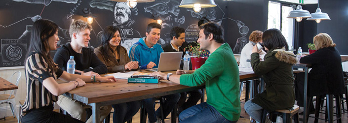 A group of students sitting around table at cafe