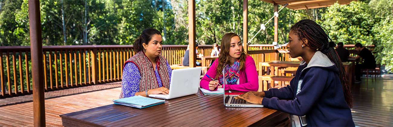 Student talking to two staff at a table