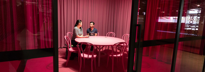 Pink room with a desk and chairs