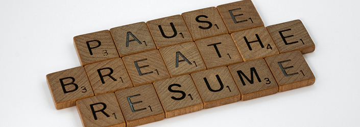 The phrase pause breathe resume written on wooden blocks